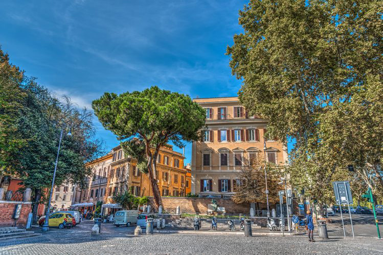 The image shows the exterior of the luxurious hotel Parrasio, located in the heart of Trastevere in Rome. The facade of the historic building has recently been renovated, creating an elegant and sophisticated atmosphere.